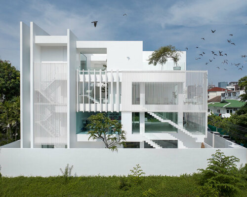 vertical white louvered surfaces enfold canvas house in bangkok