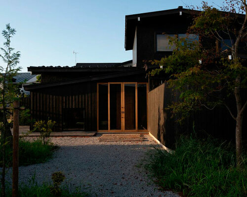 old japanese timber farmhouse transforms into modest hotel with U-shaped gardens