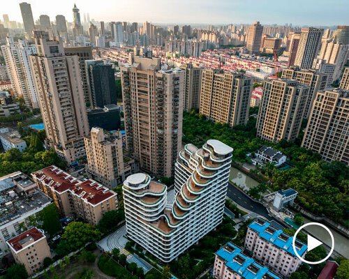 curvilinear high-rise residential building by EID reflects the nearby riverside in shanghai