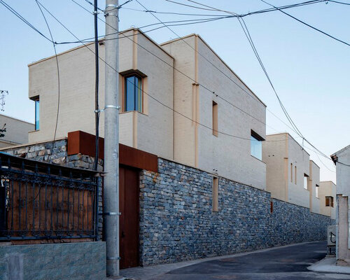 eight interconnected stone-clad buildings compose long circle B&B in beijing