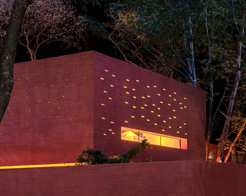 mix architecture sculpts this 'red box' exhibition center like a glowing cave