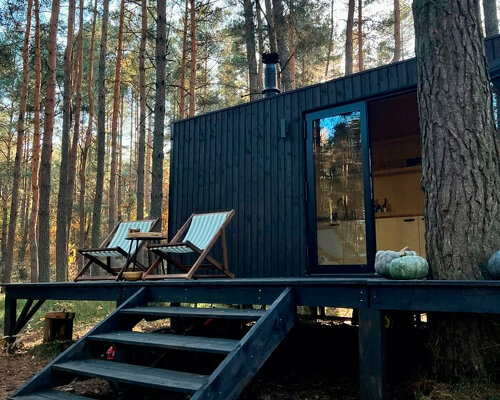 darkened plywood coats REDUKT's mobile tiny cabin offering an off-grid retreat