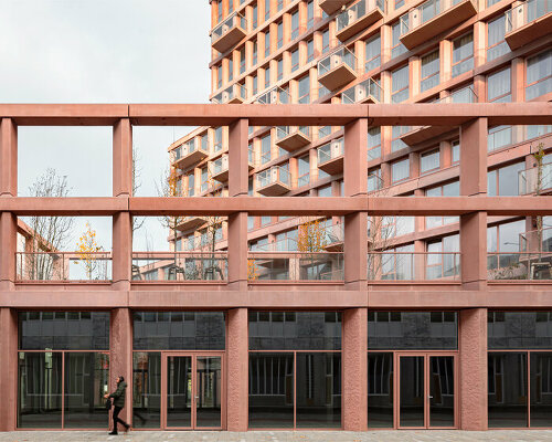 a dynamic colonnade enwraps studioninedots' mixed-use red concrete tower in almere