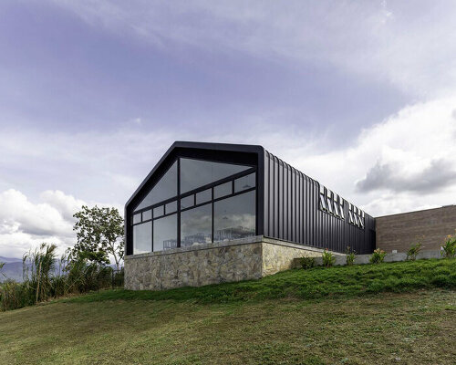 black metal sheets run along elongated volume of community dining space in ecuador