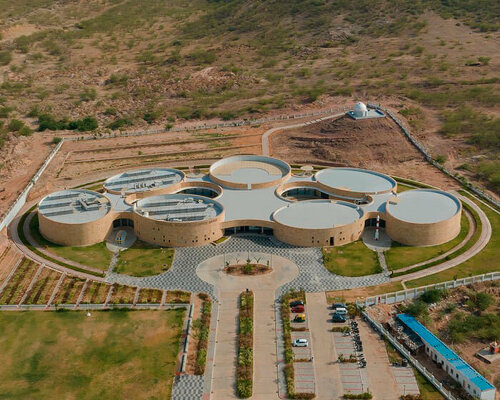 elliptical stone-clad galleries by ini design studio compose science center in india