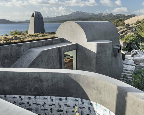 a house in sardinia by stefania stera emerges as a monolith of granite and crushed lava stone