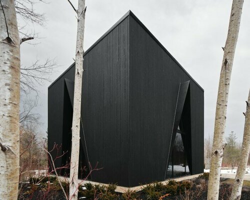 charred wood ski chalet by atelier RZLBD tucks into sloping terrain in rural canada