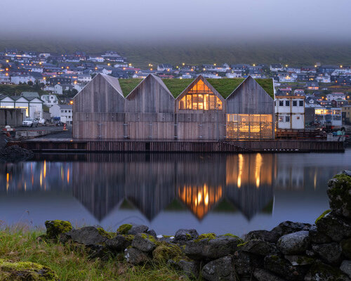 henning larsen's klaksvík row club is backdropped by the faroe islands' fjords