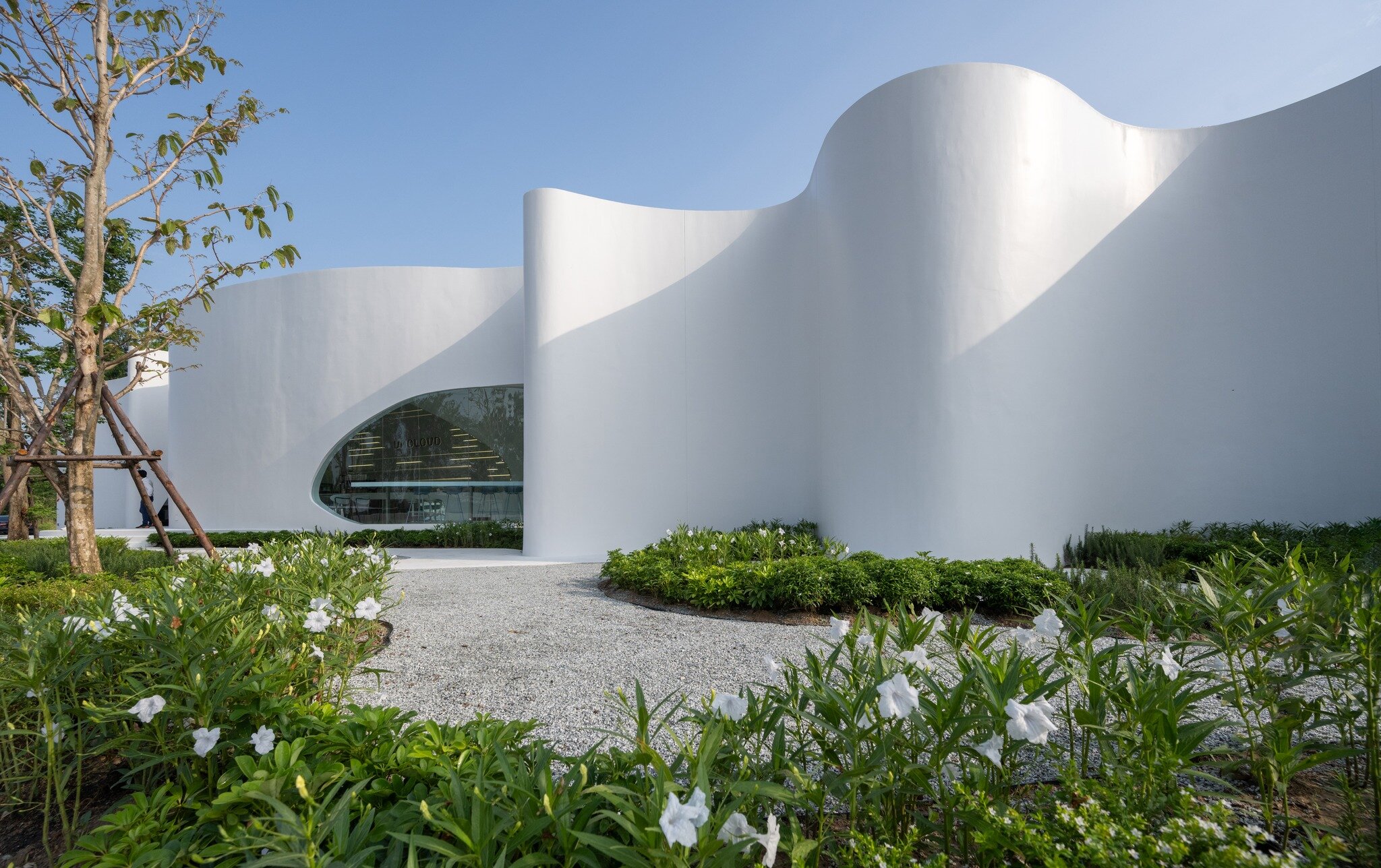 uncloud coffee's arching white structure integrates smoothly into its ...