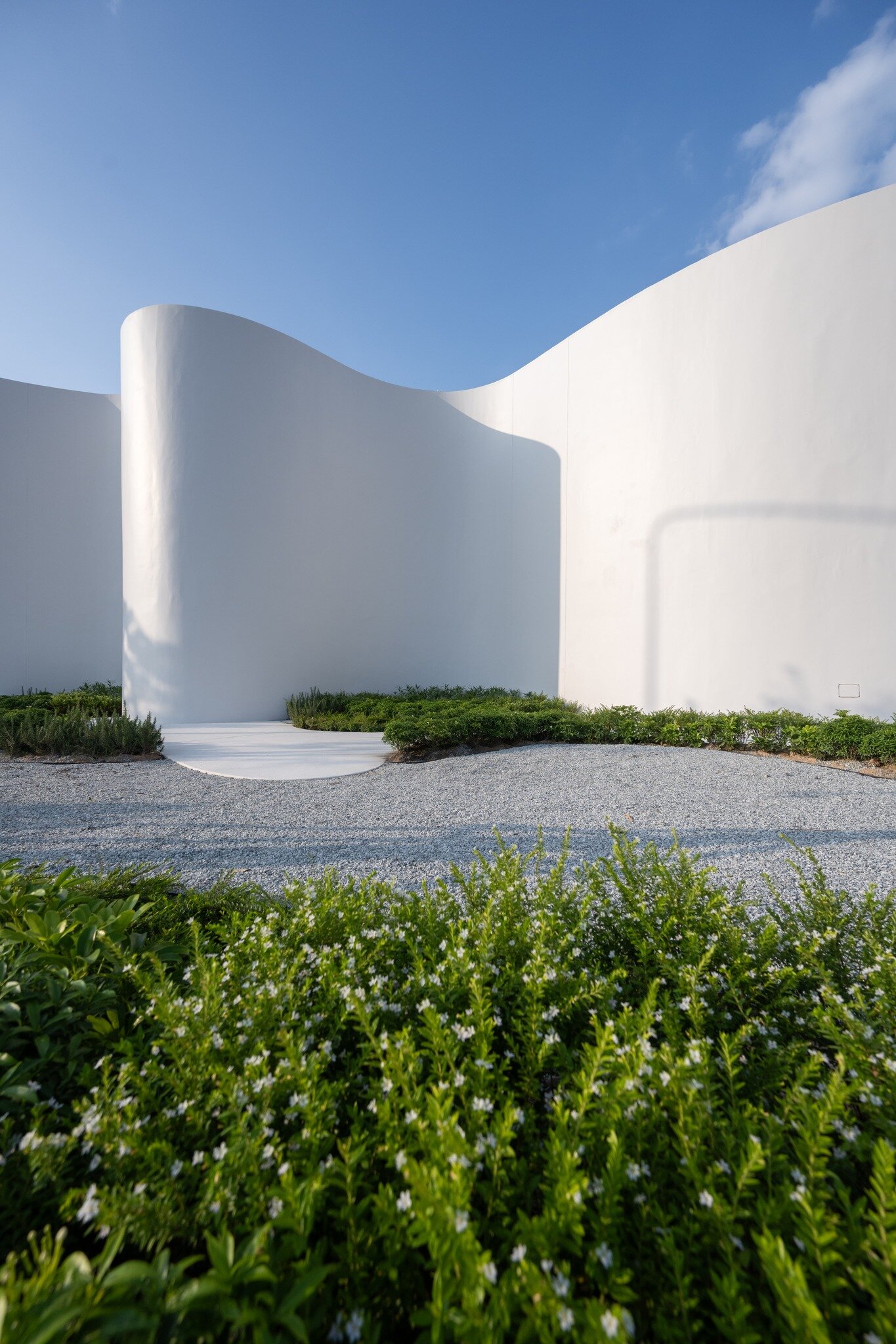 uncloud coffee's arching white structure integrates smoothly into its ...