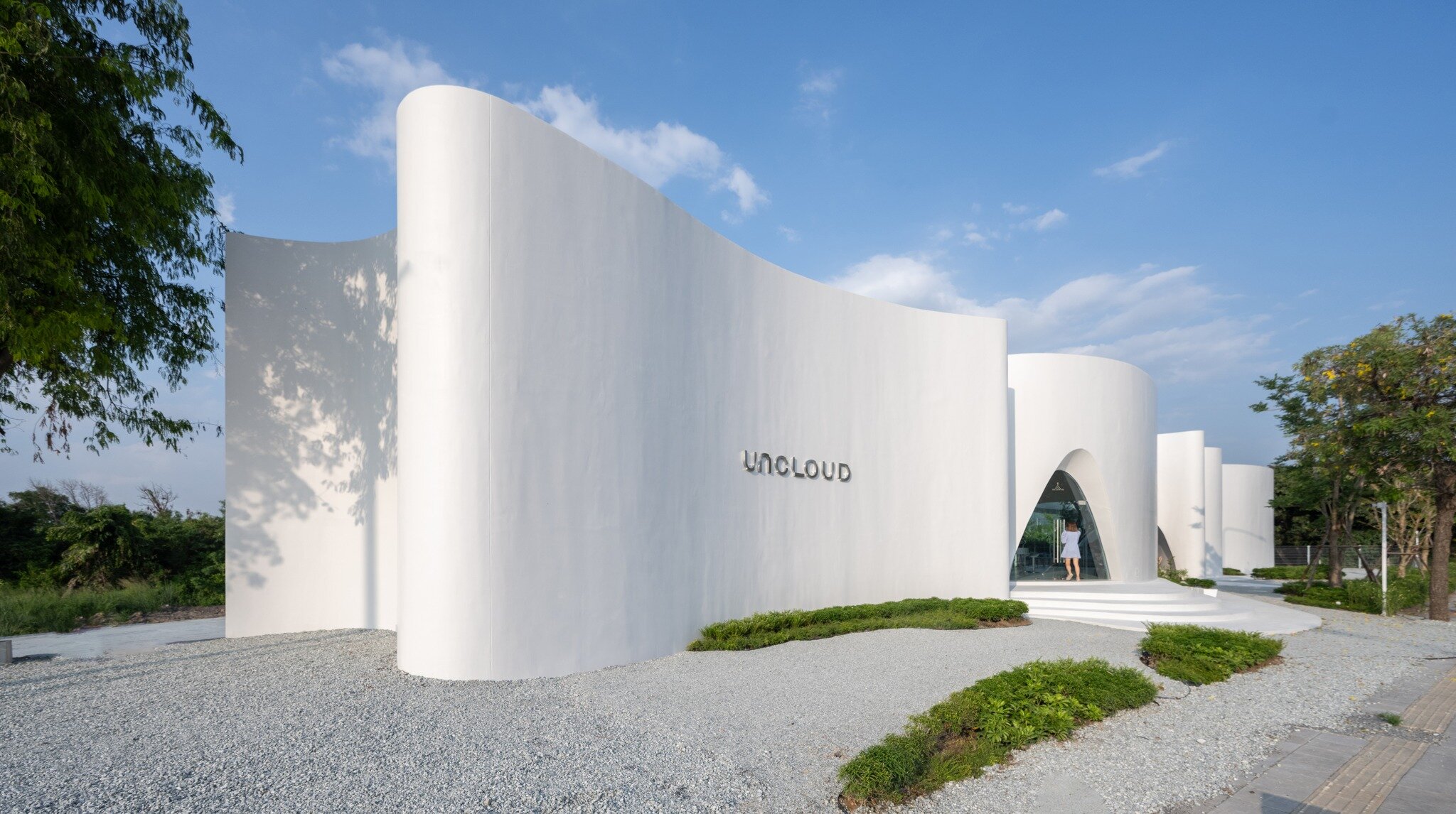 uncloud coffee's arching white structure integrates smoothly into its ...