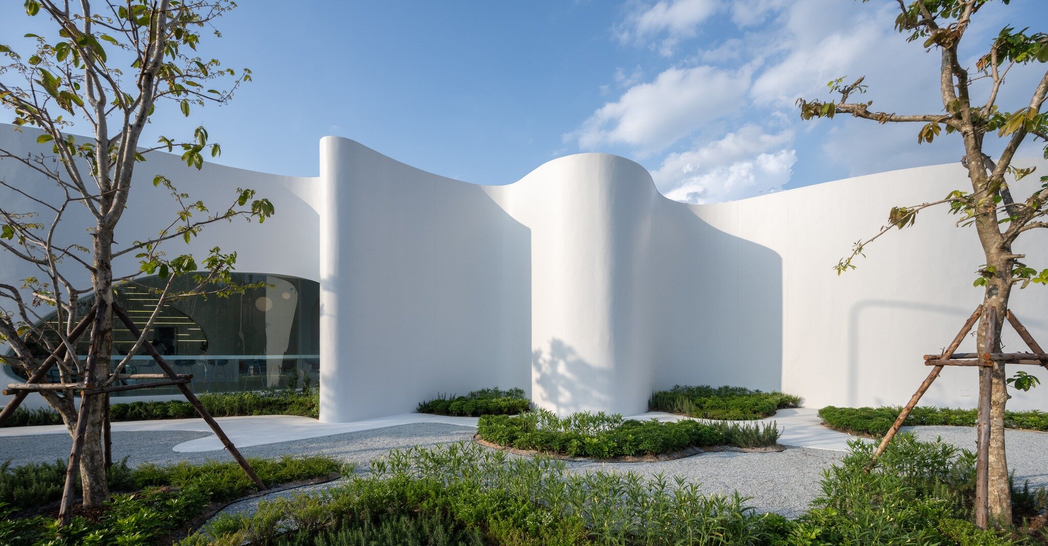 uncloud coffee's arching white structure integrates smoothly into its ...