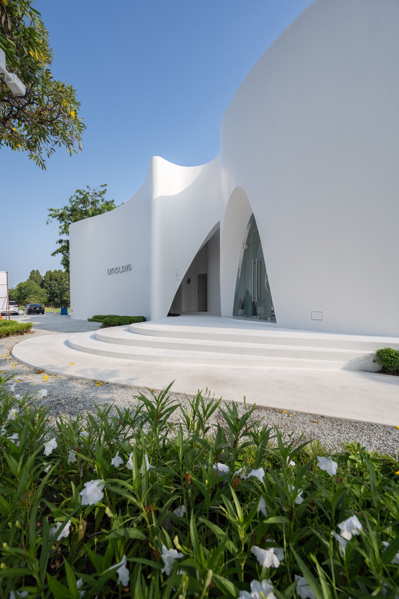 uncloud coffee's arching white structure integrates smoothly into its ...