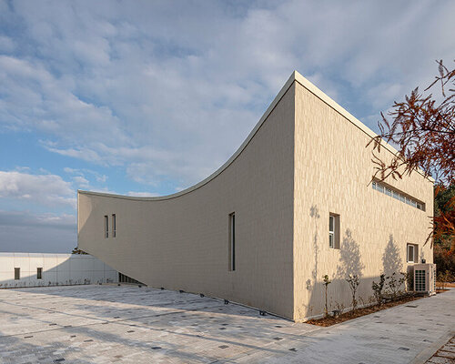 praud sculpts crescent-shaped cultural welfare center for farmers in south korea