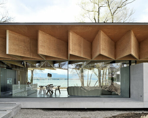 origami-like wooden panels unfold on top of ba holz house sitting along lake geneva