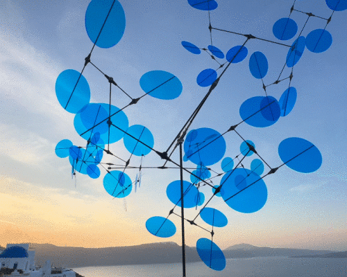 blue point cloud mobile by vincent leroy dances against the sky of santorini