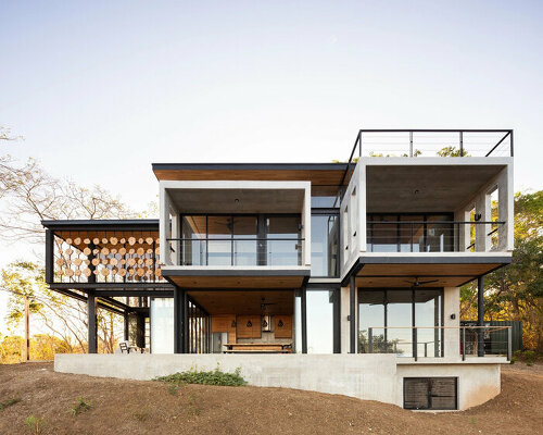 tree trunk slats filter sunlight within k10 studio's ocean villa in costa rica