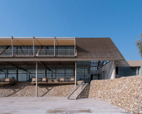 honey-colored gravel walls delineate PHTAA's restaurant by river kwai in thailand