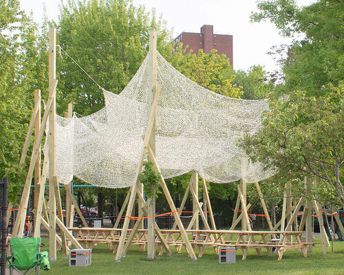 vanishing community room by alsar atelier uses tree stakes and textile canopies for shading