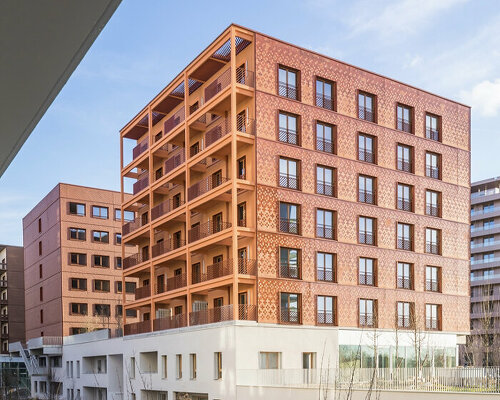 matte terracotta tiles in dynamic patterns outline athletes' village in paris