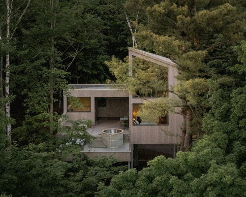 _naturehumaine's pine-wrapped chalet peaks through treetrops of canadian woodlands