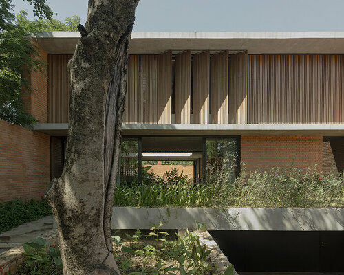 perforated wooden blinds and brick walls filter light within nofe house in paraguay