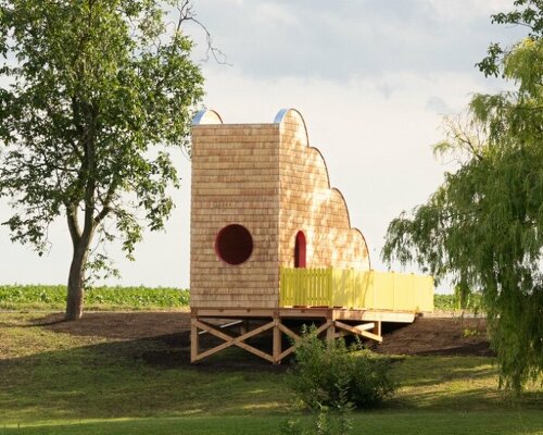 wrapped in wooden shingles, cloud-shaped cyclist shelter ascends to views over iron curtain