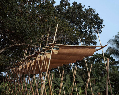 tensile fabric weaves through studio terratects' wooden trestle pavilion in india