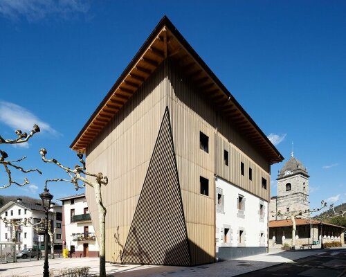 vertical wooden slats clad irura town hall's polyhedral facade in spain