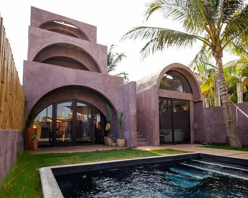 palm trees become part of casa onda's arched facade in guatemala surf town