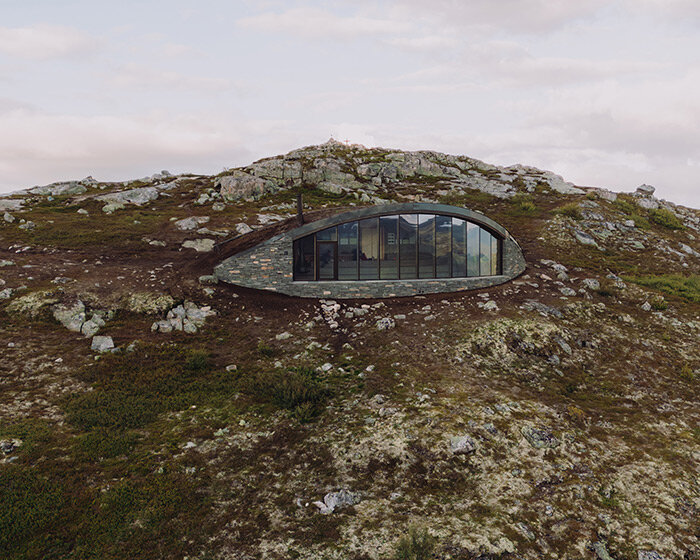 gazing over scenic norway, aksent arkitekter's day-trip cabin is embedded into a mountain