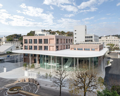 colored concrete buildings emerge from cloud-like floating roof at japanese campus