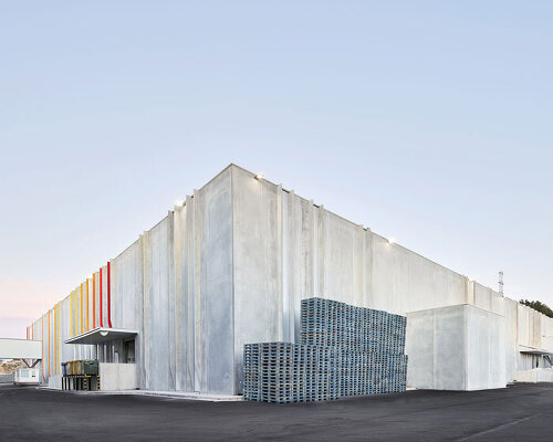 red and orange grooves brighten up factory's concrete facade by ARQUID in barcelona