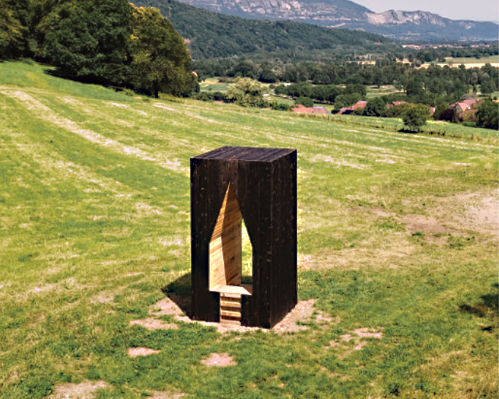 triangular void punctures lake odyssey hut's wooden monolith in fields of france