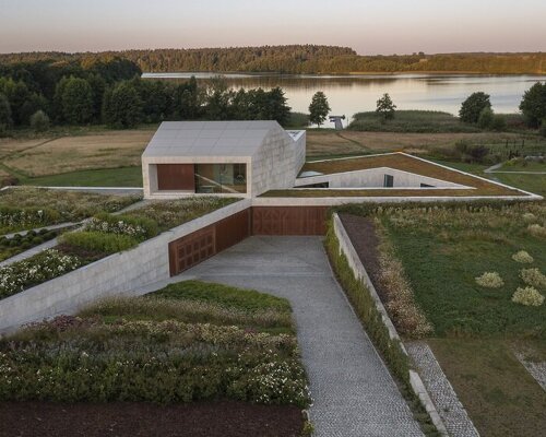 modern stone-clad farmhouse by mobius architekci folds along polish landscape's nooks