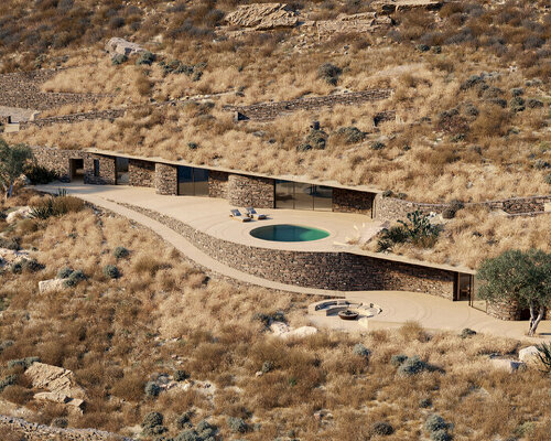 stone-clad rhoēs villa by sinas architects emerges like water ripples on serifos island