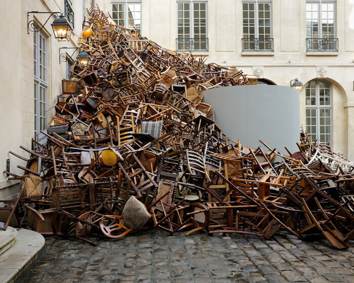 tadashi kawamata's tumbling avalanche of wooden chairs sweeps through paris courtyard