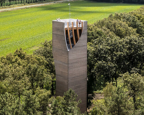 curved aperture in NEXT architects' watchtower reveals wooden frame and spiral staircase