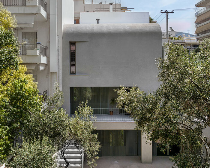 solid concrete facade shields renovated low-rise casa d's garden in athens