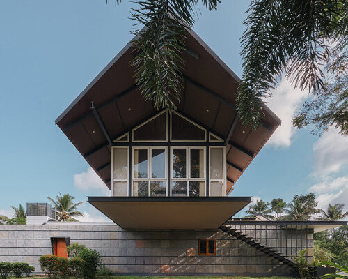 pitched roof volume cantilevers from thomas parambil's house amid kerala paddy fields