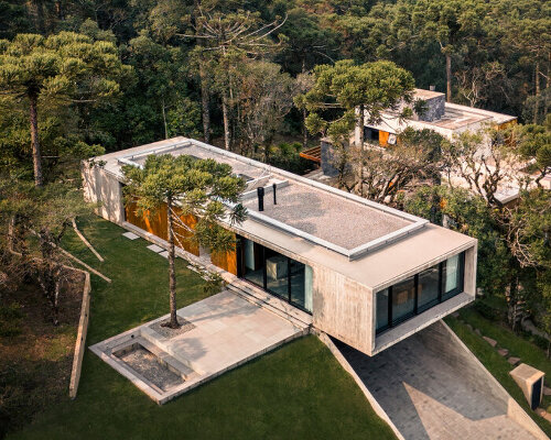 OSPA's concrete altos house cantilevers at a forested brazilian hilltop