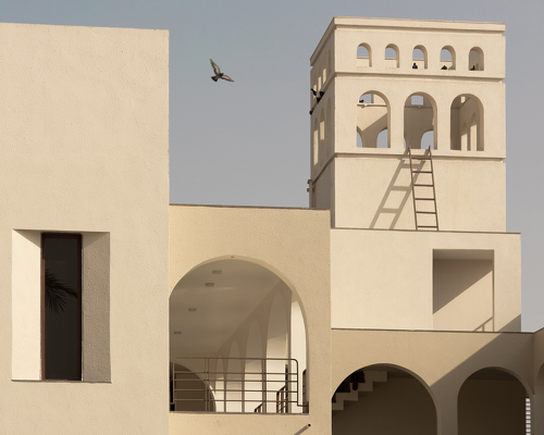 arches carve into ivory-colored walls of raasa architects' ashram in indian village