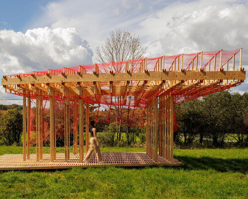 red mesh drapes over wooden curtain call pavilion by office office in woodstock's grounds