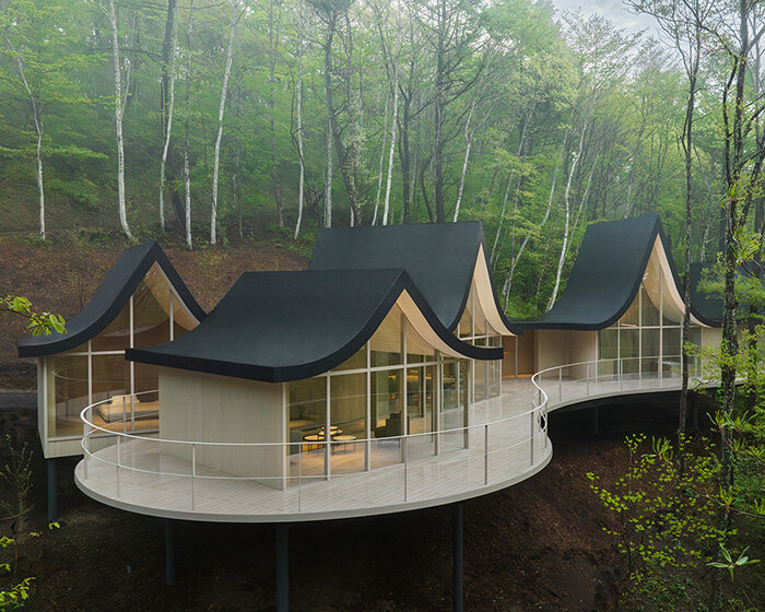 nendo weaves six cottages together with ‘hand-holding’ roofs in japanese forest house