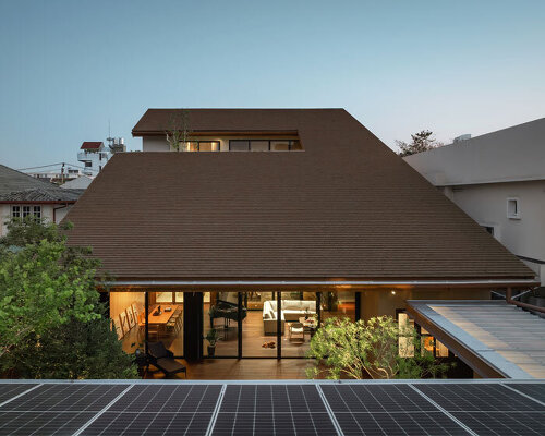 cut-out sloped roof covers three-layered residence in thailand