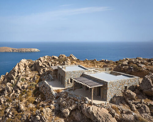 exposed stone masonry fuses restored residence by c-o lab with greek island's rocky terrain