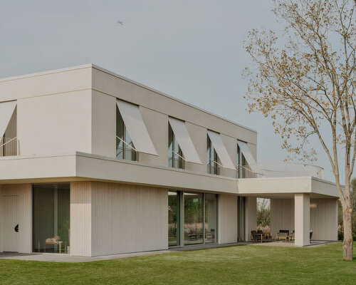 GAISS rests house's linear symmetrical volume on timber-clad plinth in latvia