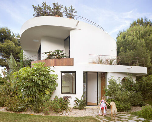 curved white volumes and verdant surroundings define house in les rotes, spain